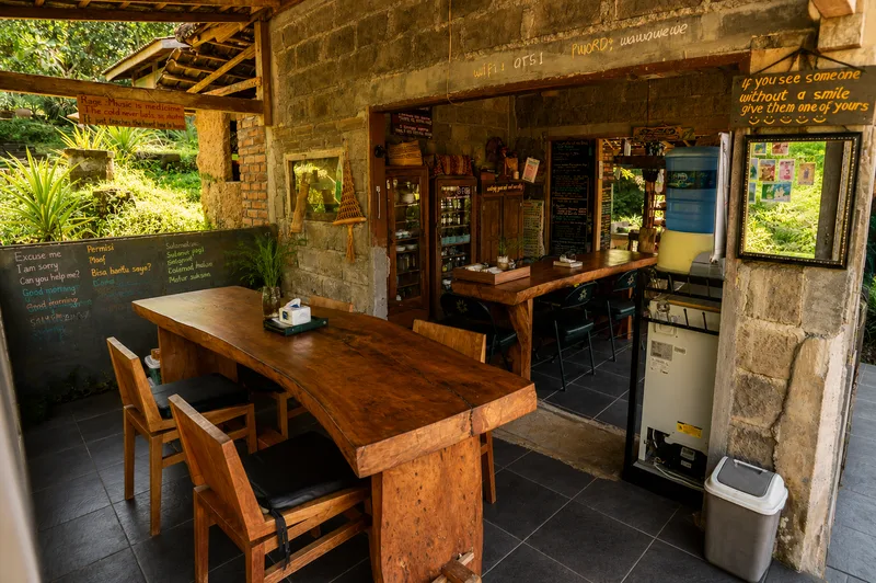 Rustic dining area with wooden tables at Oemah Tepi Sawah